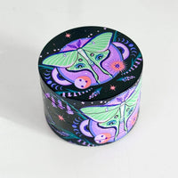 2.5 inch diameter purple aluminum 4 piece grinder with black background and green moth with celestial and floral design bliss shop chicago