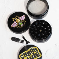 canna style 2.5 inch diameter black aluminum 4 piece grinder with beetle encrusted in lavender gems & pearls on top lid bliss shop chicago