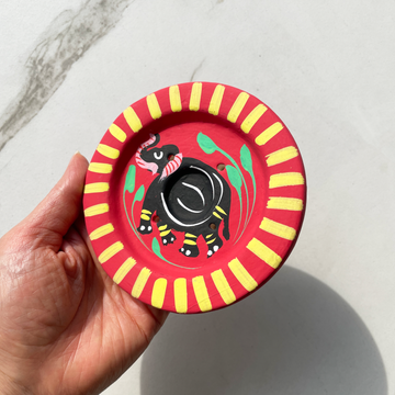 4 inch round hand painted red terracotta incense burner with yellow design and black elephant in center for incense sticks and cones bliss shop chicago