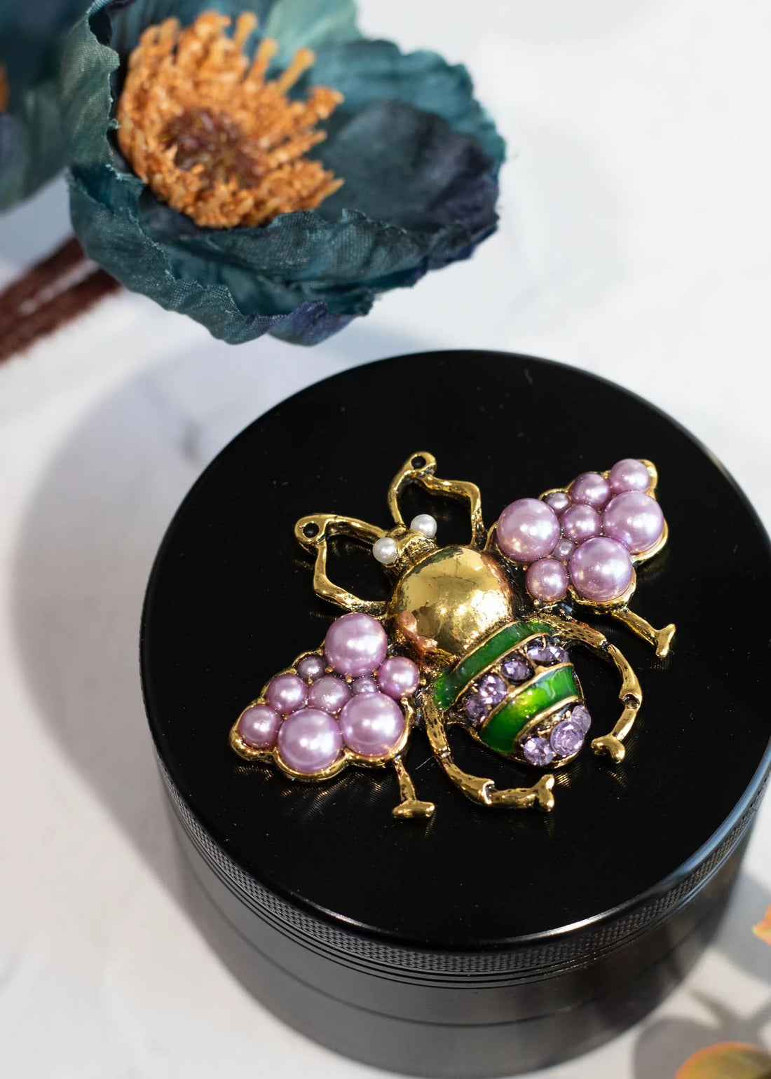 canna style 2.5 inch diameter black aluminum 4 piece grinder with  beetle encrusted in lavender gems & pearls on top lid bliss shop chicago