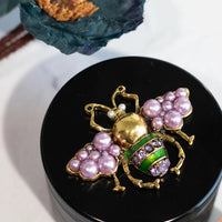 canna style 2.5 inch diameter black aluminum 4 piece grinder with  beetle encrusted in lavender gems & pearls on top lid bliss shop chicago