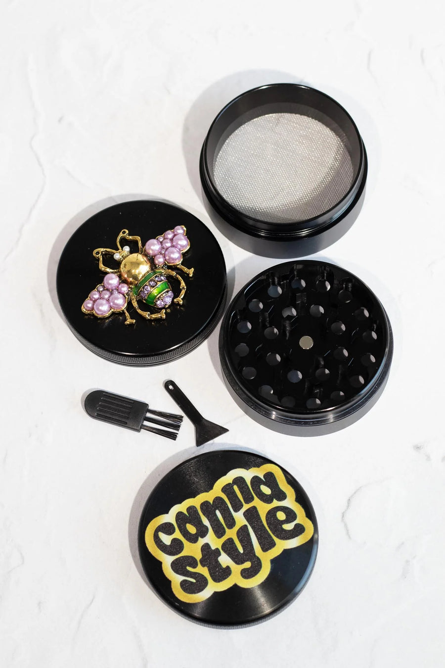 canna style 2.5 inch diameter black aluminum 4 piece grinder with  beetle encrusted in lavender gems & pearls on top lid bliss shop chicago