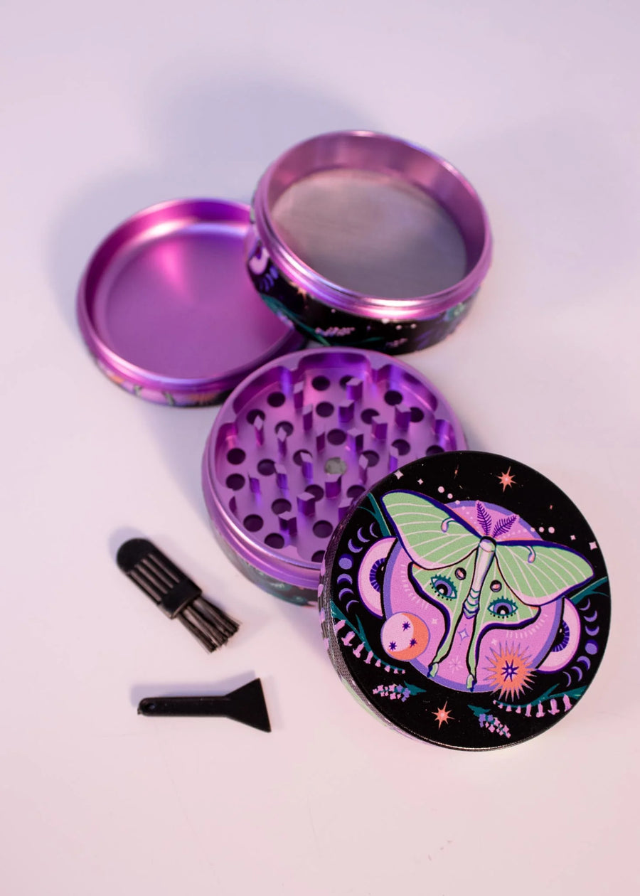 2.5 inch diameter purple aluminum 4 piece grinder with black background and green moth with celestial and floral design bliss shop chicago