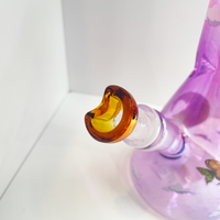10 inch beaker bong with light purple base that transitions to bright pink at top with large celestial moon, butterflies and cloud decals. includes crescent moon shaped slide.  bliss shop chicago