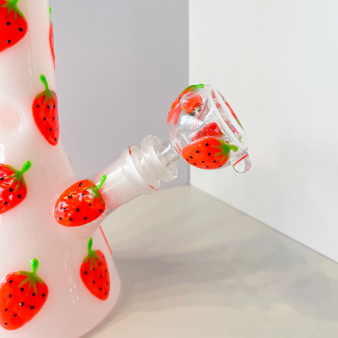 10 inch white beaker bong with bright red strawberry designs that glow in the dark bliss shop chicago