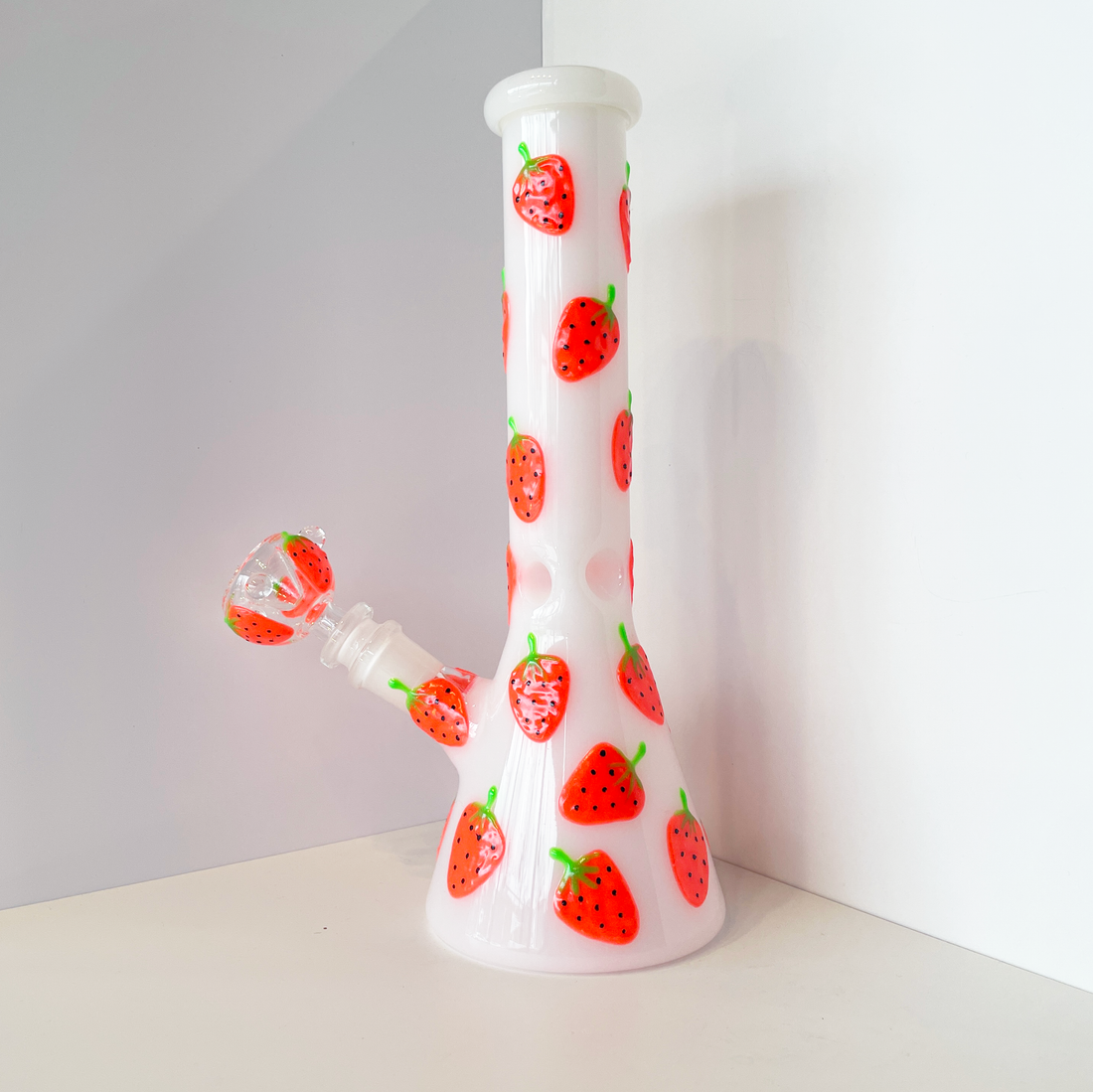 10 inch white beaker bong with bright red strawberry designs that glow in the dark bliss shop chicago